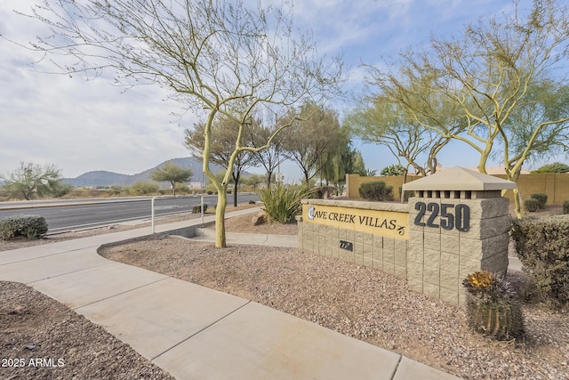 community / neighborhood sign with a mountain view