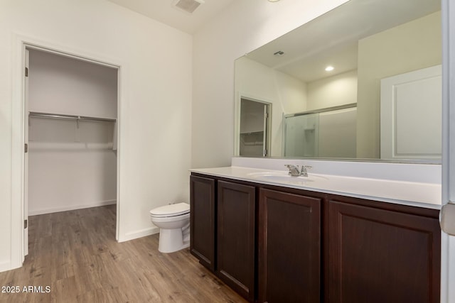 bathroom featuring vanity, toilet, hardwood / wood-style floors, and a shower with shower door