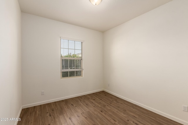 unfurnished room with dark hardwood / wood-style flooring