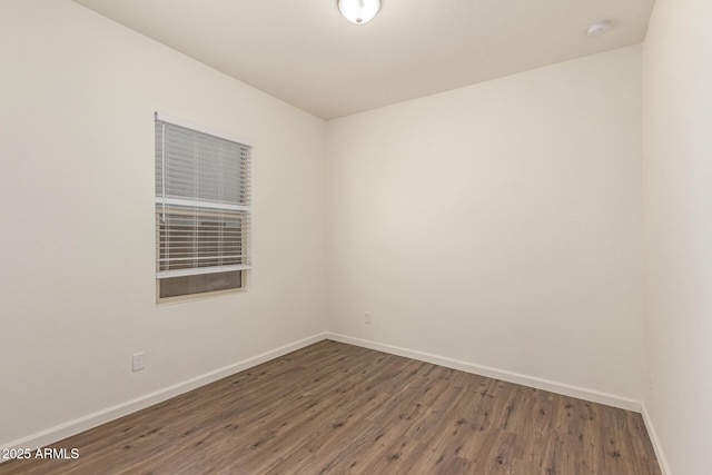 empty room with dark hardwood / wood-style flooring