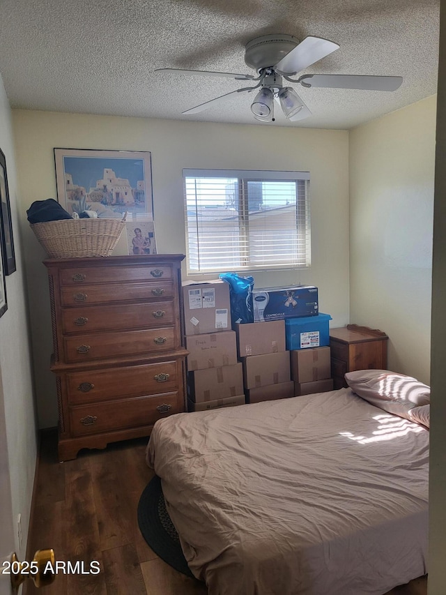 bedroom with dark wood-type flooring, ceiling fan, and a textured ceiling