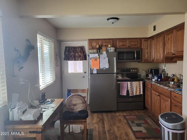 kitchen with dark hardwood / wood-style flooring, sink, stone countertops, and appliances with stainless steel finishes