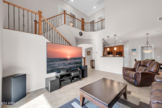 living room featuring a towering ceiling and light tile patterned floors