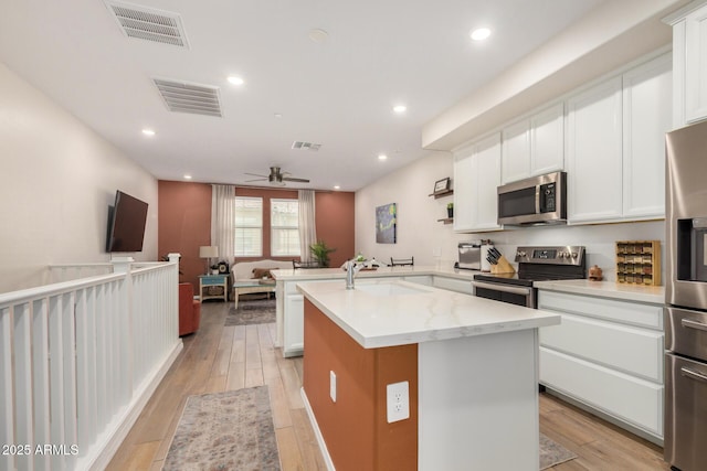 2631 S Sulley Dr Unit 106, Gilbert, AZ 85295 - kitchen with stainless steel appliances, a sink, light wood-style floors, ceiling fan, and recessed lighting