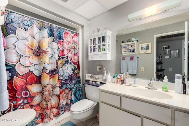 bathroom featuring tile patterned flooring, vanity, toilet, and walk in shower