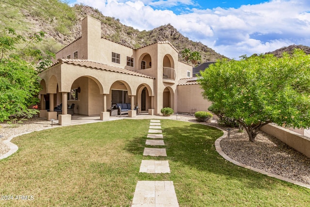 back of house with a mountain view, a lawn, outdoor lounge area, and a patio