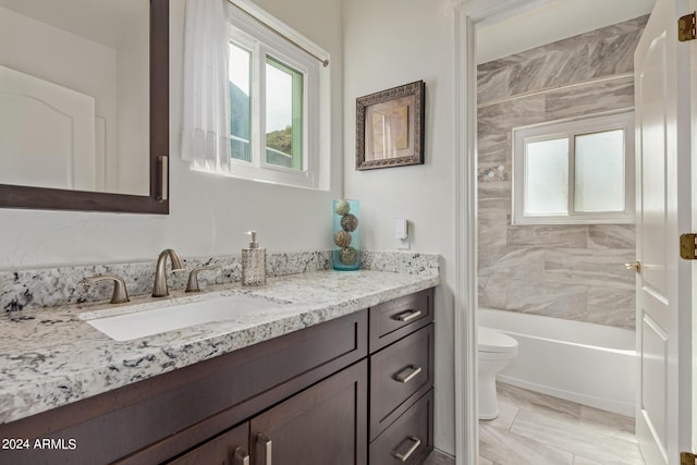 full bathroom with vanity, tiled shower / bath combo, and toilet