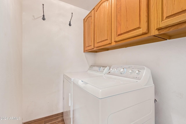 laundry room with cabinets and washing machine and clothes dryer