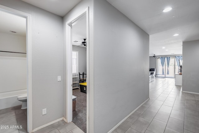 corridor with recessed lighting, tile patterned flooring, and baseboards