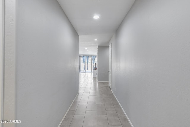 hall with recessed lighting and baseboards