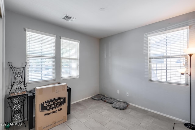 unfurnished room featuring baseboards and visible vents