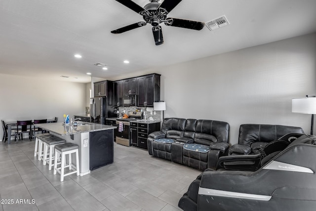 living room featuring visible vents, ceiling fan, and recessed lighting