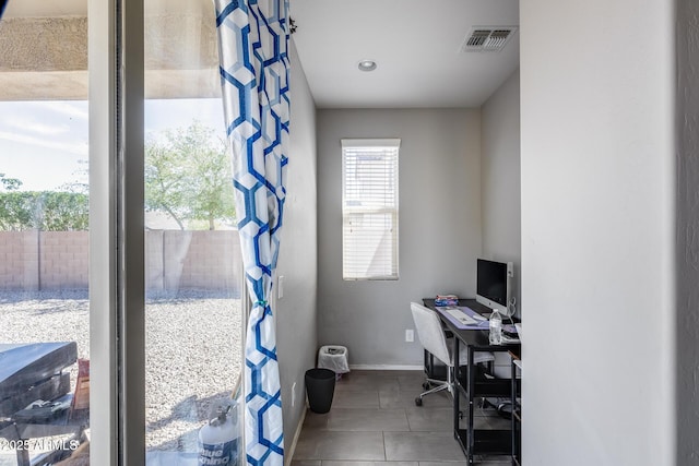 tiled office space featuring visible vents and baseboards