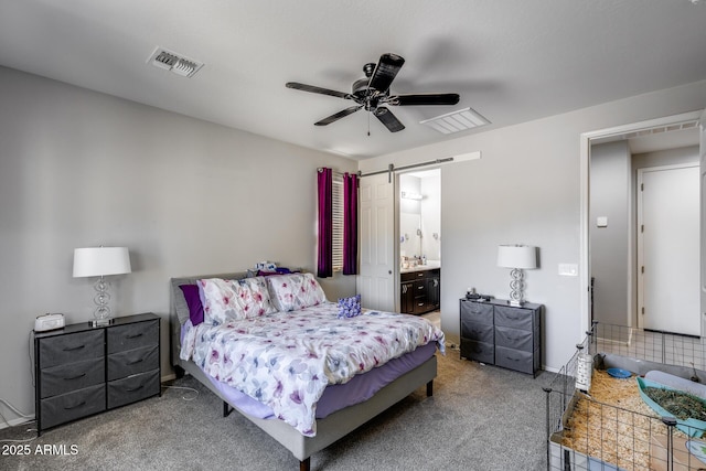 carpeted bedroom featuring visible vents, ceiling fan, a barn door, and ensuite bathroom