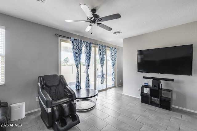 sitting room with visible vents, plenty of natural light, a ceiling fan, and baseboards