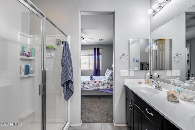 ensuite bathroom featuring a stall shower, ceiling fan, ensuite bath, and vanity