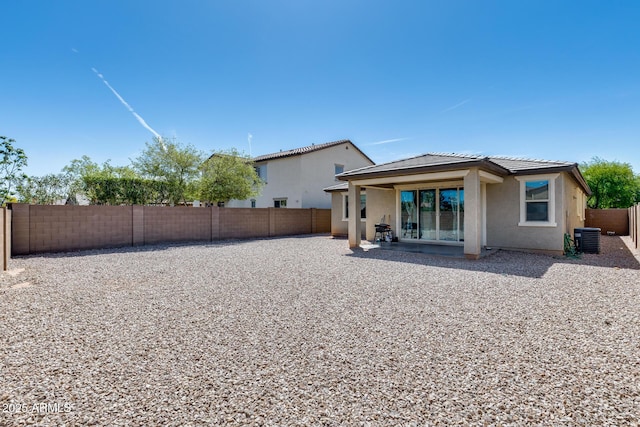 back of house featuring a fenced backyard, stucco siding, central AC unit, a tile roof, and a patio area