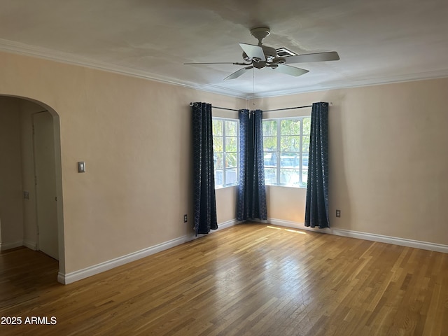 empty room featuring crown molding, wood-type flooring, and ceiling fan