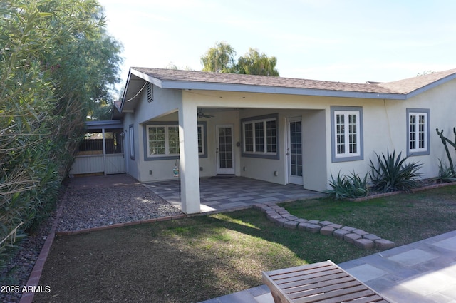 rear view of house featuring a yard, a patio area, and ceiling fan