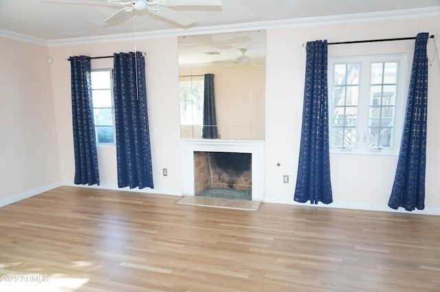 unfurnished living room with ornamental molding, ceiling fan, a fireplace, and light hardwood / wood-style floors