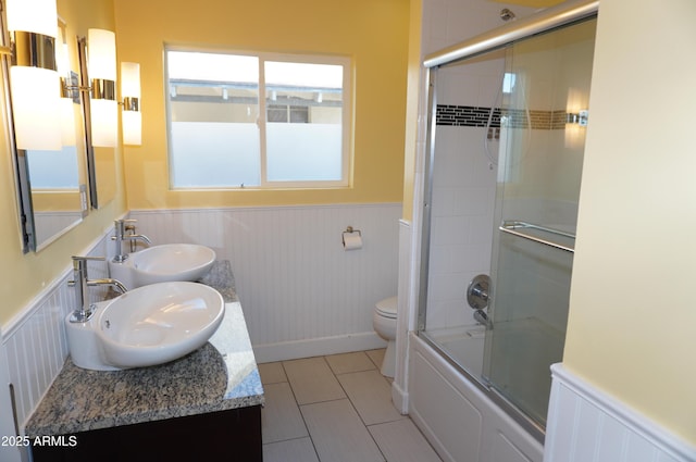 full bathroom featuring tile patterned floors, toilet, combined bath / shower with glass door, and vanity