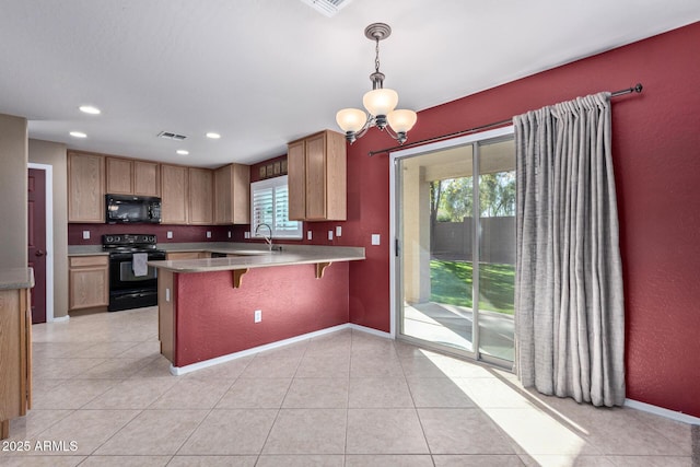 kitchen with pendant lighting, black appliances, a kitchen bar, kitchen peninsula, and a chandelier