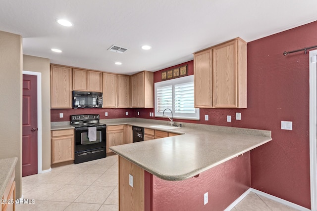 kitchen featuring sink, kitchen peninsula, a kitchen bar, light brown cabinetry, and black appliances