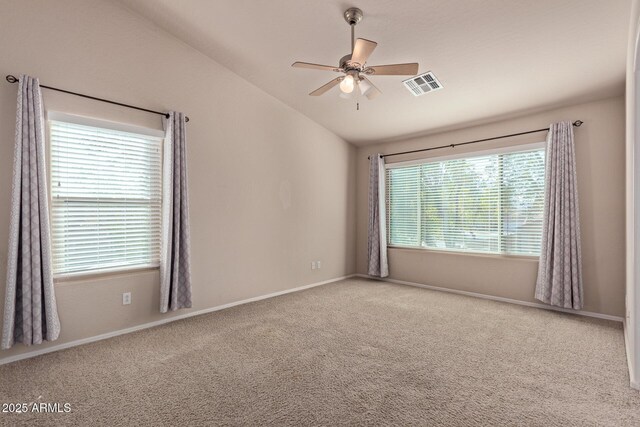 unfurnished room with light colored carpet, vaulted ceiling, and ceiling fan