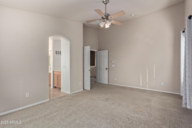 unfurnished bedroom with connected bathroom, ceiling fan, and light carpet