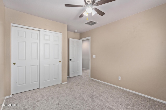 unfurnished bedroom with ceiling fan, a closet, and light colored carpet