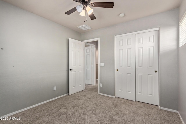 unfurnished bedroom featuring ceiling fan, a closet, and light carpet