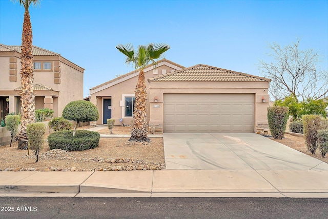 mediterranean / spanish home with driveway, an attached garage, a tile roof, and stucco siding