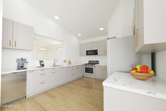 kitchen with black microwave, a sink, light wood-style floors, range, and dishwasher