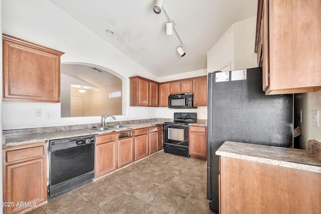 kitchen featuring lofted ceiling, light countertops, a sink, and black appliances