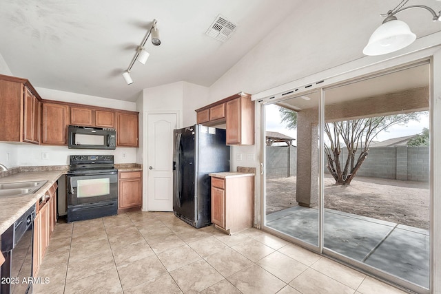 kitchen featuring brown cabinets, light countertops, visible vents, a sink, and black appliances