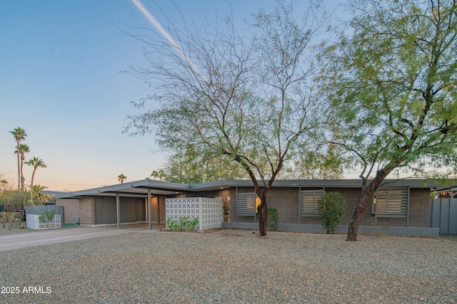 view of front facade with driveway, an attached carport, and brick siding