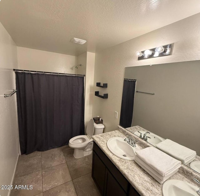 bathroom with vanity, tile patterned floors, toilet, a textured ceiling, and walk in shower