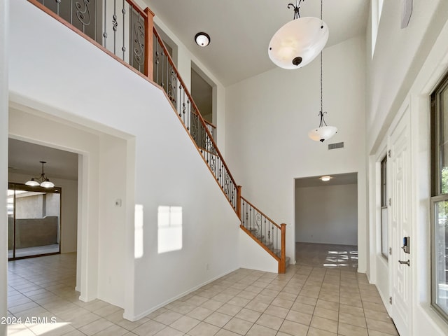 entryway with a high ceiling and light tile patterned floors