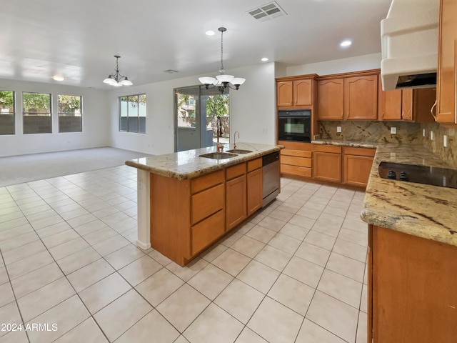 kitchen featuring black appliances, light stone counters, an inviting chandelier, a center island with sink, and decorative light fixtures