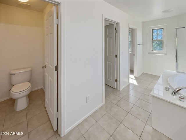 bathroom featuring tile patterned flooring, a washtub, and toilet