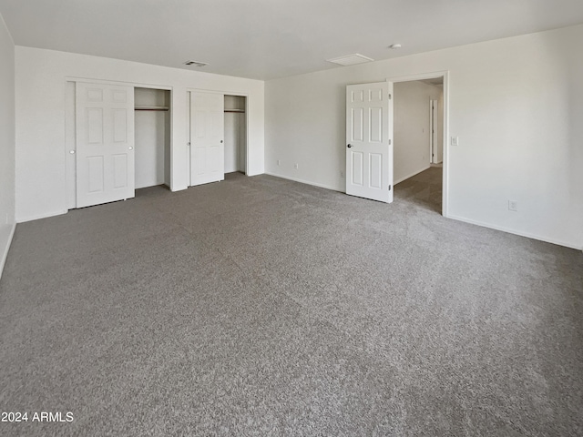 unfurnished bedroom with dark carpet