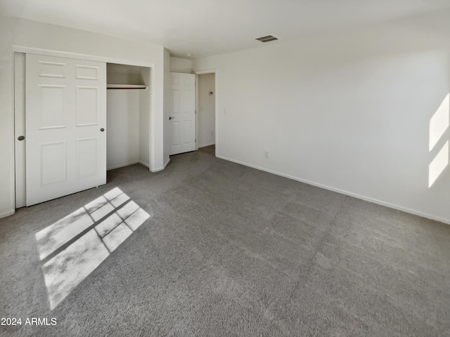 unfurnished bedroom with a closet and carpet flooring