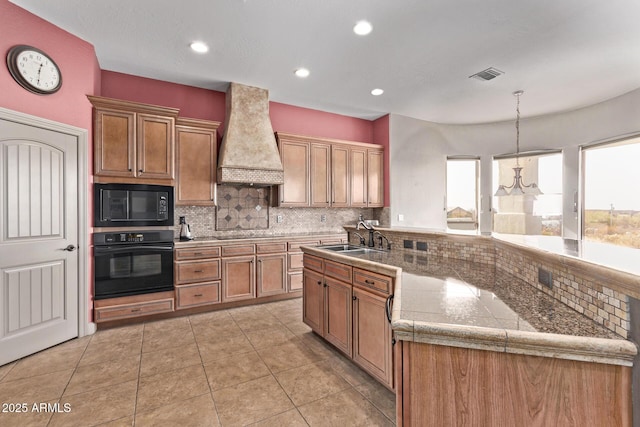 kitchen featuring pendant lighting, black appliances, custom exhaust hood, tasteful backsplash, and sink