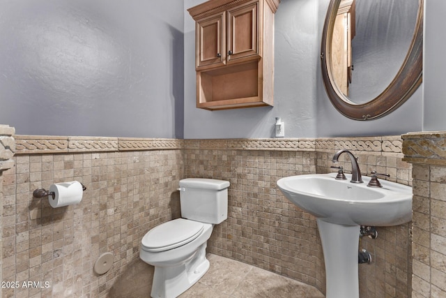 bathroom featuring toilet, tile walls, and tile patterned flooring