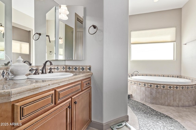 bathroom featuring tiled bath, vanity, and tile patterned flooring