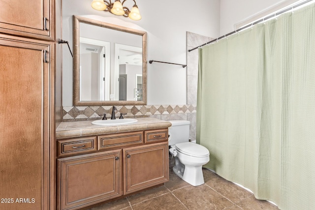 bathroom featuring vanity, toilet, tile walls, and tasteful backsplash