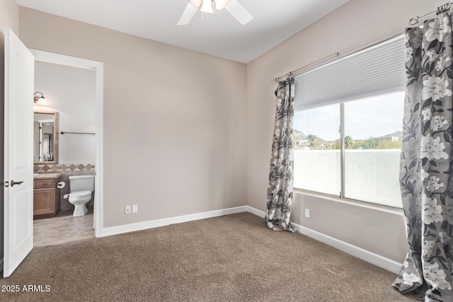 bedroom with ceiling fan, carpet, and ensuite bathroom