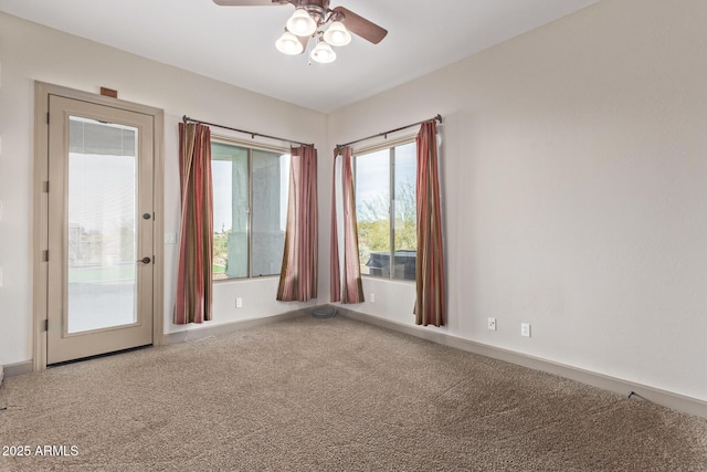 carpeted spare room featuring ceiling fan