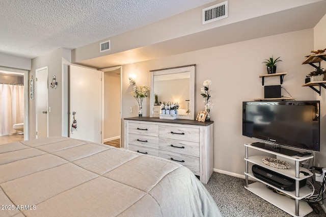 carpeted bedroom featuring baseboards, visible vents, ensuite bath, and a textured ceiling
