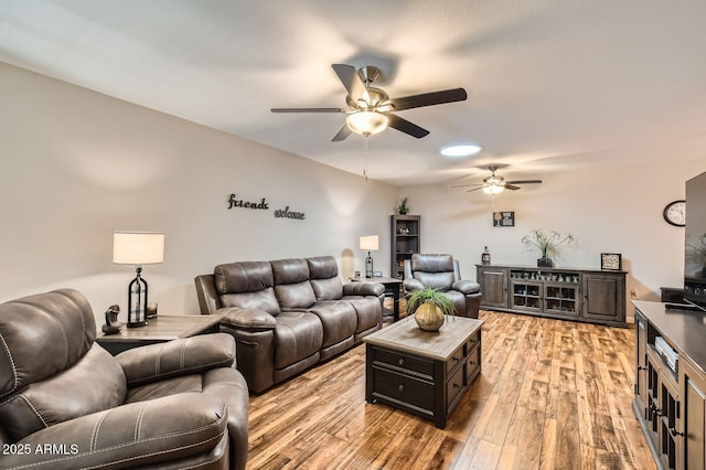living area with a ceiling fan and light wood-style flooring